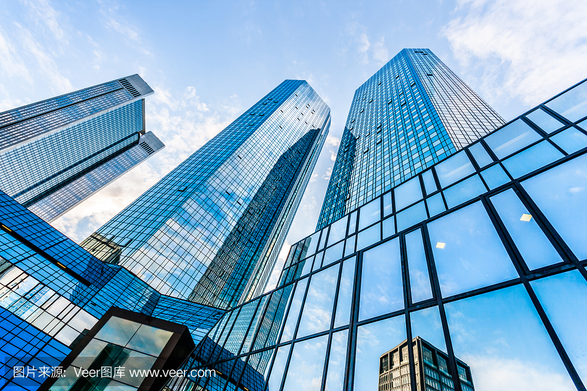 在蓝天白云的映衬下,现代摩天大楼的底部视图